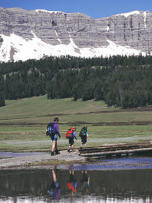 Day hikers along the shore of Brooks Lake with Breccia Cliffs in background in the Shoshone National Forest, located in northwestern Wyoming