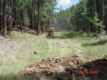 Heavy machinery is used to level the Woods Canyon stilling pond after years of streamflow had erroded the streambed.