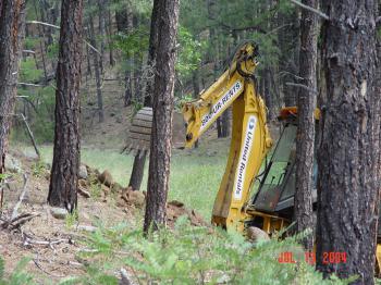 Heavy machinery is used to level the Woods Canyon stilling pond after years of streamflow had erroded the streambed.