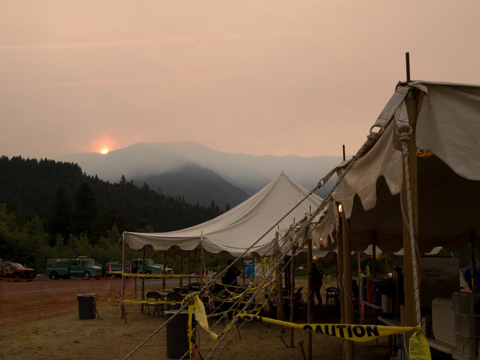 Large tents with open sides staged at a forest fire.