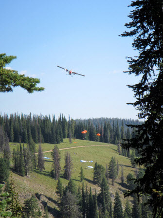 An aircraft drops cargo to wildland firefighters on the ground on the Salmon-Challis National Forest.