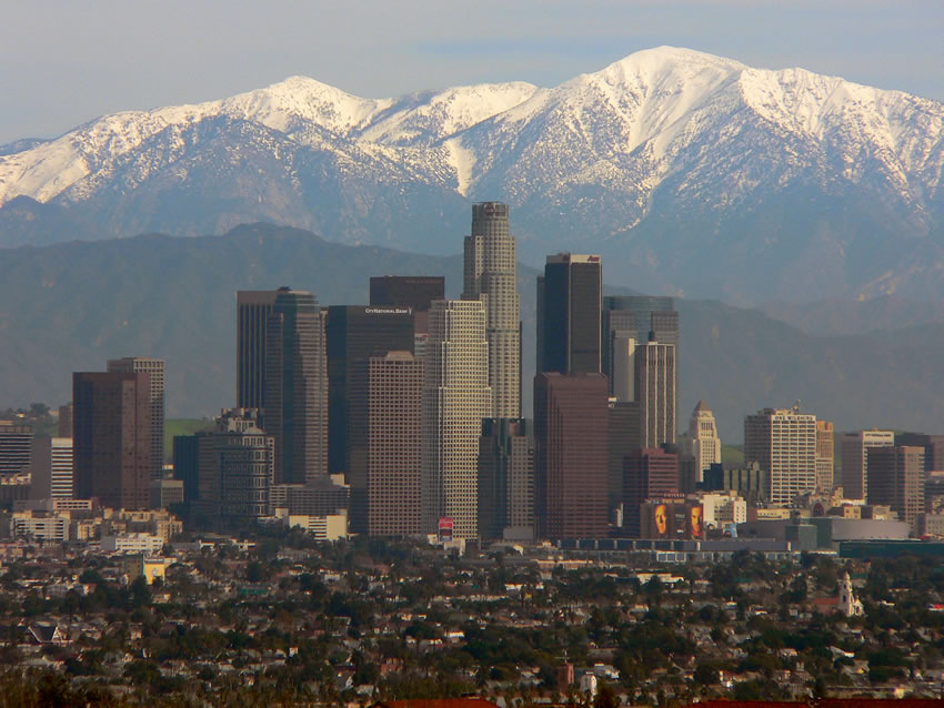 View of the skyline of Los Angeles with the San Gabriel Mountains in the background.
