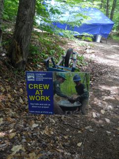A sign saying crew at work marks the youth conservation corps campsite.