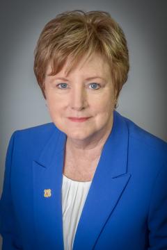 Portrait: Cynthia West wearing blue suit jacket with Forest Service lapel pin.