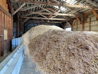 A picture of a large pile of wood chips in a storage building.