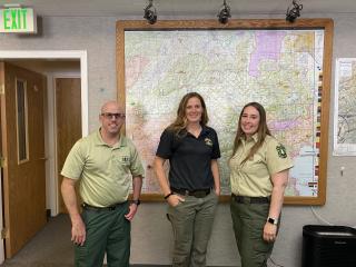 The Tahoe National Forest Dispatch team in front of a map of the forest