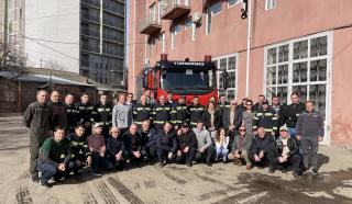Workshop participants in two rows. Gathered in front of an engine outside Tbilisi's fire station.
