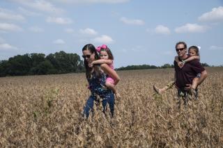 A family of four walks through a field.