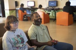 Recreation supervisor plays video game with Job Corps Student.