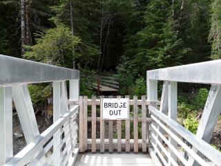 A gate and "BRIDGE OUT" sign at the end of the Big Four Ice Caves bridge before repairs.
