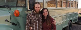 Forest Service helitack firefighter, Jay Beus, and his wife, Ren Beus, stand in front of the bus they use as living quarters.