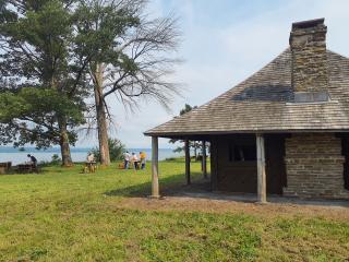 Foreground: Historic Queen's Castle. In background, volunteers at the worksite and campsite on Seneca Lake.