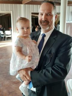 A man wearing a suit and tie holding a baby girl