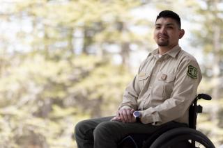 man in Forest Service uniform sitting in a wheel chair 
