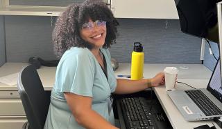 African American woman smiles at desk