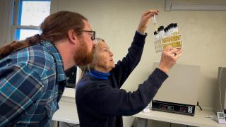 Two people looking at test tubes in a lab.