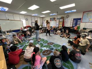 A group of children sitting on the floor in a classroom