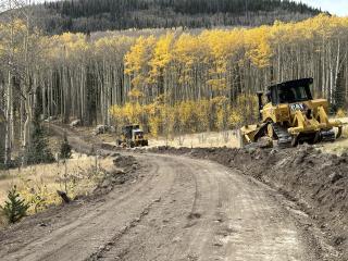 Grader and bulldozer along a dirt road being built in Rio Grande National Forest.