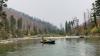 Resource specialists, in a raft on the river, are conducting a work survey.