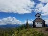 A view of Hornet Lookout, a cabin in a clearing on top of a small hill overlooking a forest