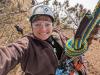 Selfie photo of Forest Service tree climbing trainee Savannah Halleaux connected to a climbing rope up in a tree