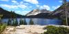 Rocky ground overlooks a mountain lake with a mountain in the background.