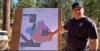 Image shows a man in a baseball cap pointing to a map of a prescribed fire plan.