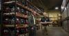 Image shows two men standing in aisles packed with equipment.