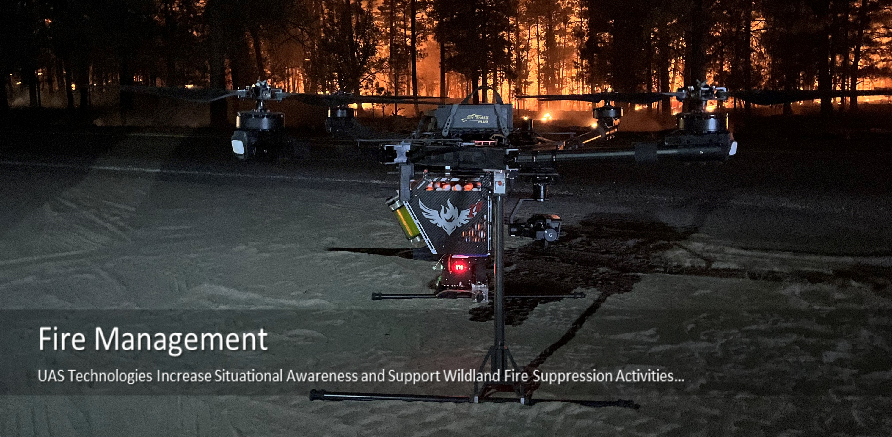 An Aerial Unmanned System or Drone on a dirt road at night with trees burning in the background.