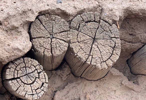 Close up of logs that are part of a traditional Santa Clara Pueblo home.