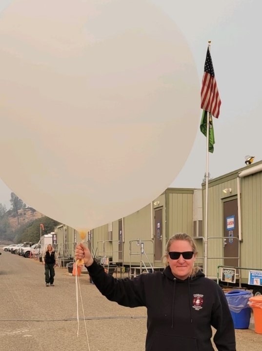 ​​Shilo Springstead, Forest Training Officer in Pacific Southwest Region 5 (California), launching a balloon to observe weather patterns and fire behavior.