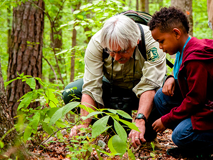 Dennis Krusac teaches a young neighbor about plants on Atlanta’s Food Forest