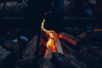 A small campfire using 4 pieces of wood and low flame.