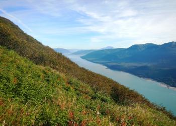Overlook view of grassy mountain and waterway.