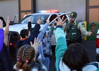 Forest Service Law Enforcement Officer interacting with school kids