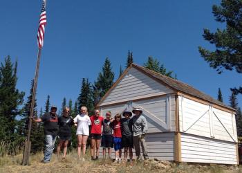 Volunteers pose for a photo in front of a FS building