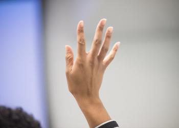A person raises their hand to ask a question.