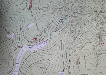 An image of a topographic map with lines for contours and water