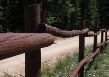 Brown painted post and pole fence.