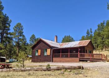 exterior of a rustic cabin with mountains in the background