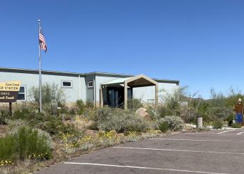 Front view of the Cave Creek Ranger Station building with a clear sky in the background.