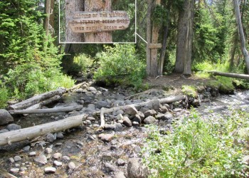 a wooden sign at the creek