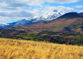 Photograph of a dry field with mountains in the background