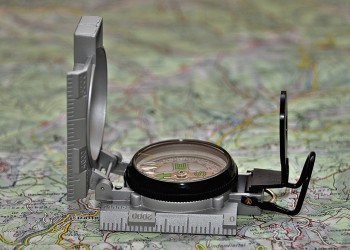 Compass open and positioned on a topo map