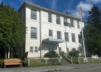 Front view of Cordova Ranger District Office building. White building with American flagpole in front.