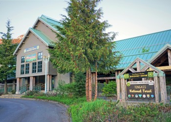 SEADC Ketchikan building with green roof, green trees out front, brown, white, green, blue signage