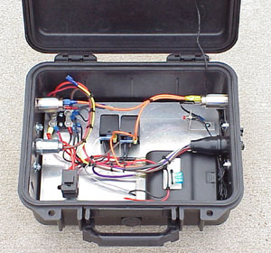 A small plastic camera case contains the receiver, relays, and other electrical components.
