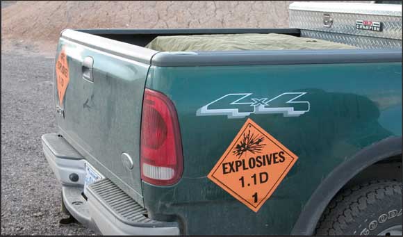 Image of a vehicle used for transporting explosives that is displaying a sign that says "Explosives 1.1D."