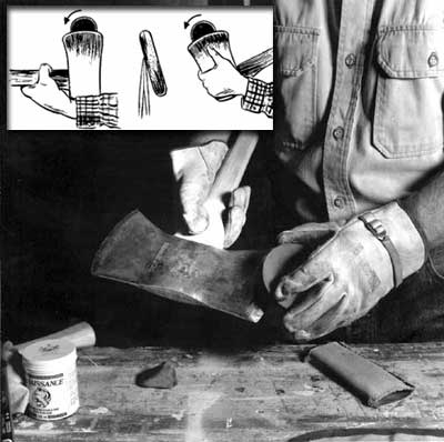 Photo of a person using an ax stone on the ax head. In the photo there is an illustration showing that the ax stone should move in a circular motion.